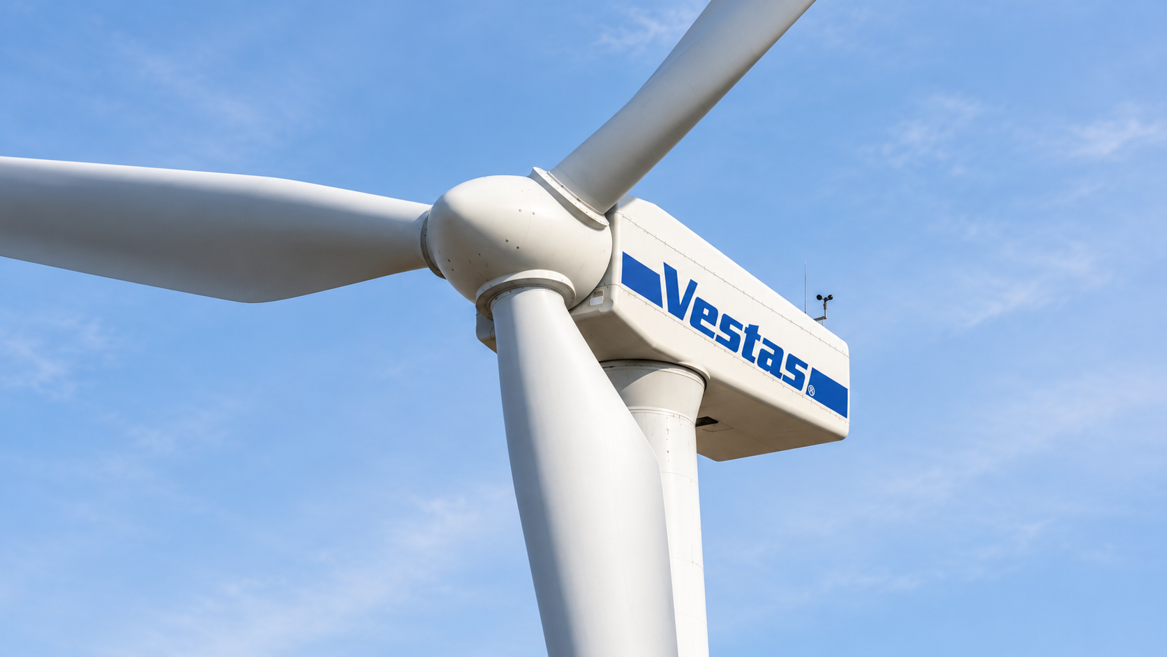 Biała turbina Vestas widziana od dołu na tle błękitnego nieba. Ilustracja wygenerowana komputerowo.